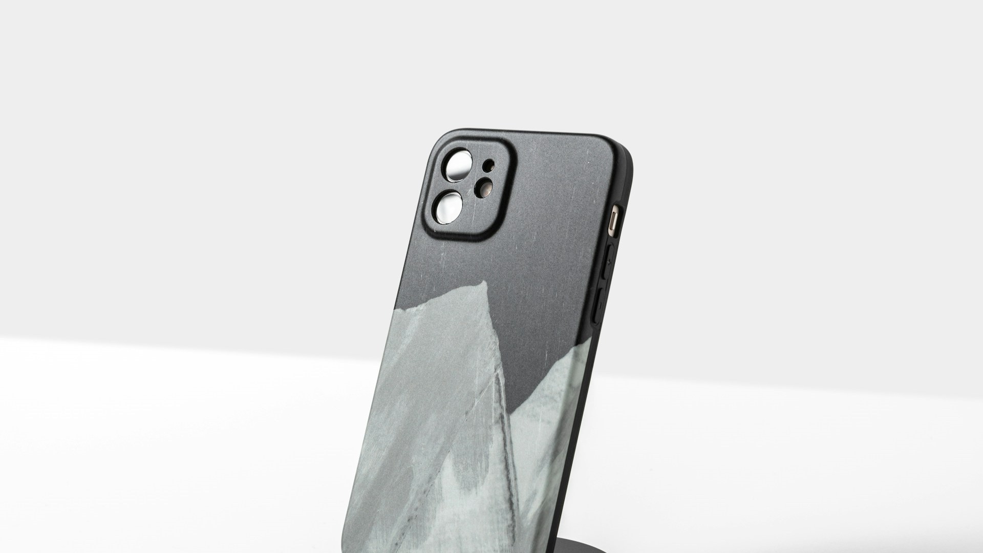 Telefoonhoesje vervangen: zwart hoesje met abstract grijs-wit bergpatroon op standaard
